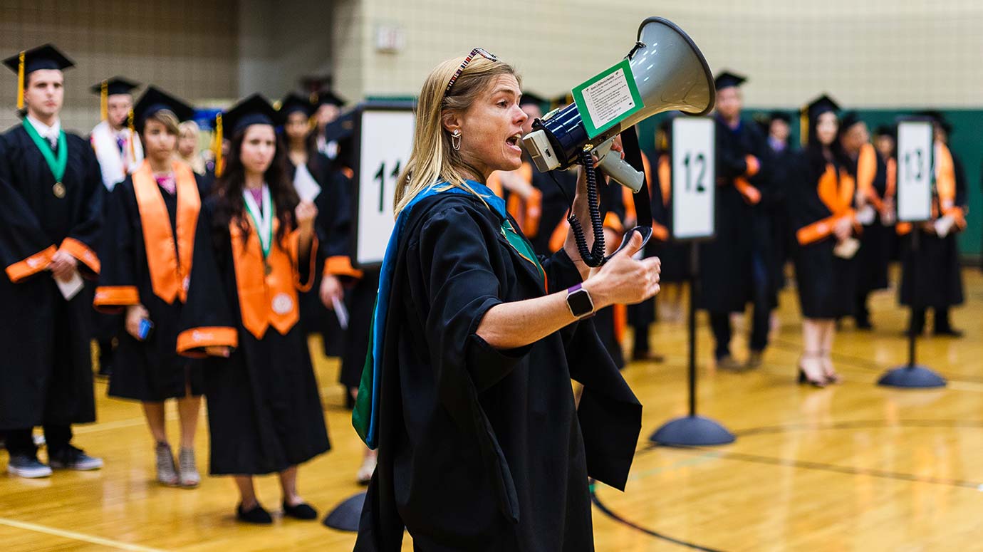 University Registrar Jennifer McDowell gives instructions about the procession to students from the School of Behavioral and Brain Sciences before their commencement ceremony